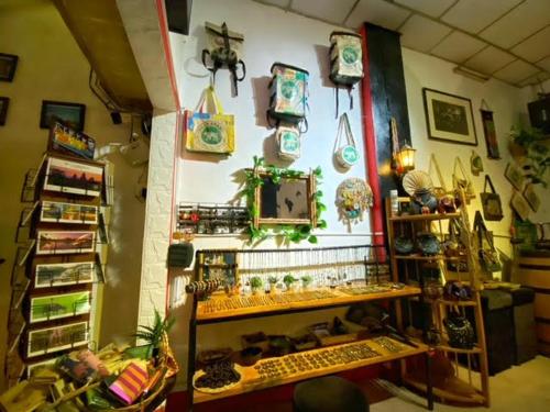 a room filled with lots of items on a wall at Pomme Hostel Restaurant & Bar - Private Sleeping Cabins in Battambang
