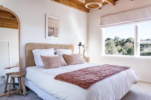 a bedroom with a large bed and a window at Sunshine Rise, Upstairs Unit, Romantic, Waterfront Retreat in Raglan