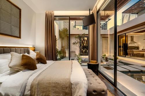 ein Schlafzimmer mit großem Bett und Glaswand in der Unterkunft Priviere Luxury Villa - Canggu in Canggu