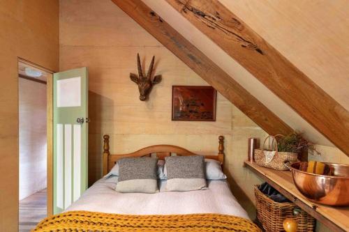una camera da letto con un letto con una testa di antilope sul muro di The Cloud House Hampton - Rustic Alpine Retreat a Lowther