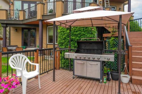 a grill and an umbrella on a deck with a chair at Villa Luna in Gig Harbor