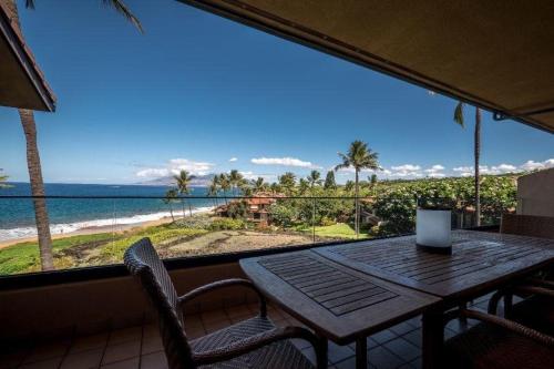 a table and chairs on a balcony with a view of the ocean at MAKENA SURF, #C-205 condo in Wailea