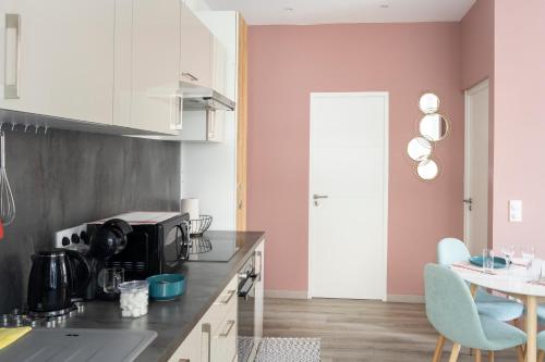 a kitchen with pink walls and a table and chairs at LIKE CASA- Centre/Gare in Valence
