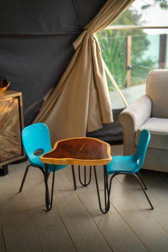 a living room with a table and two chairs at Chira Glamping Resort Monteverde in Monteverde Costa Rica