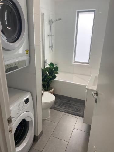 a bathroom with a washing machine and a toilet at Waterfront 209 in Paihia