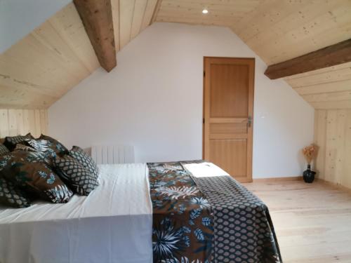 ein Schlafzimmer mit einem großen Bett im Dachgeschoss in der Unterkunft L'Alcôve des Falaises in Rochefort-sur-Nenon