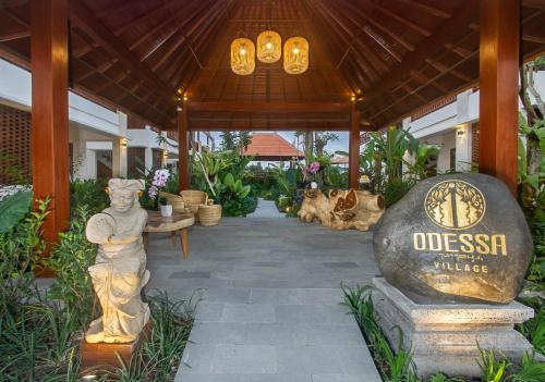 a entrance to a resort with a statue and a sign at Odessa Village by Pramana Villas in Gianyar