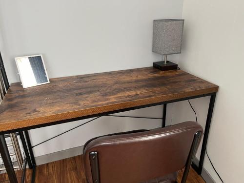 a wooden desk with a lamp and a chair at GuestHouse紫雲 -SHIUN- in Toyohama