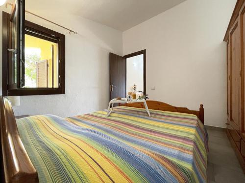una camera con un letto con una coperta colorata di Holiday home in Costa Rei 22891 a Costa Rei
