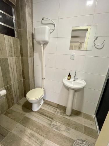 a bathroom with a toilet and a sink at Res Hostel 01 in Santa Cruz do Sul