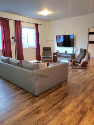 a living room with a couch and a flat screen tv at Cribs on the Hill in Picton