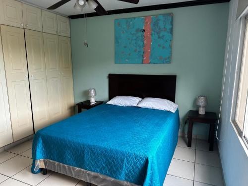 1 dormitorio con 1 cama con colcha azul en MonBlanc, en San Salvador