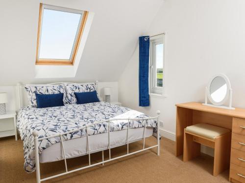 1 dormitorio con cama, escritorio y espejo en Mulberry Cottage - Uk45432, en Isle of Whithorn