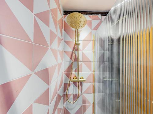 a bathroom with pink and white geometric tiles at St Peters Sq in Ruthin