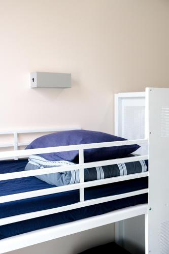 a white bed with blue sheets on it at Wake Up! Sydney Central in Sydney