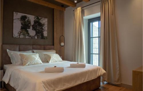 sypialnia z dużym łóżkiem z dwoma ręcznikami w obiekcie Amazing Home In Gruda With House A Panoramic View w mieście Gruda