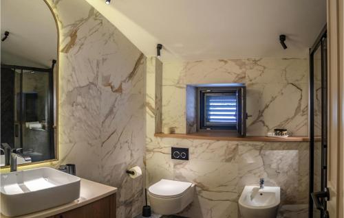 W łazience znajduje się umywalka, toaleta i lustro. w obiekcie Amazing Home In Gruda With House A Panoramic View w mieście Gruda