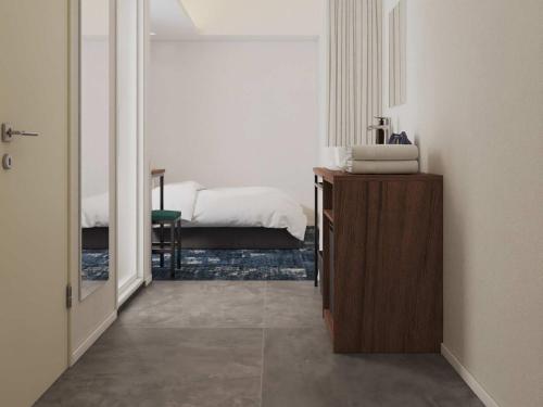 a room with a bedroom with a bed and a mirror at Prince Smart Inn Miyazaki in Miyazaki