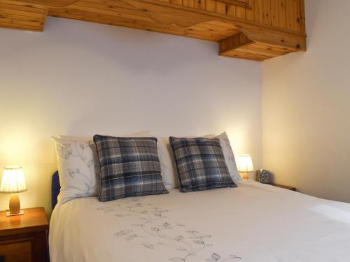 a bedroom with a white bed with two pillows at Mount Cottage in Wennington