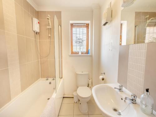 a bathroom with a toilet and a tub and a sink at Fair Isle Holiday Cottages - Hill Top Cottage in Newport