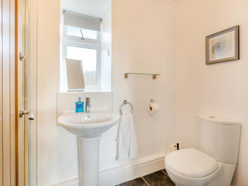 a white bathroom with a toilet and a sink at Overshot - Uk45388 in Crewkerne