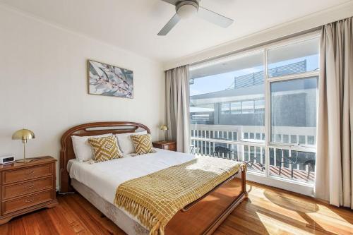 una camera da letto con un letto e una grande finestra di Beyond the Blue - Beachfront Beauty on Your Doorstep a Melbourne