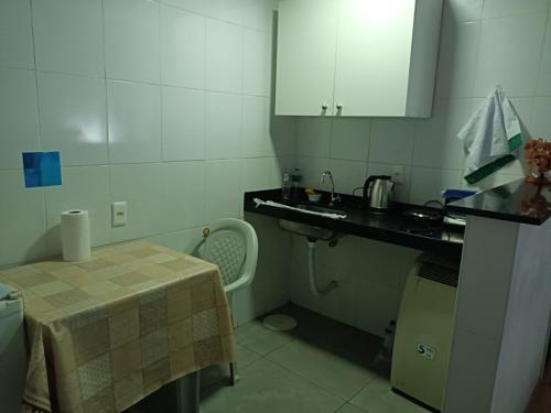 uma pequena cozinha com uma mesa e um lavatório em Apartamento Centro Belo Horizonte em Belo Horizonte