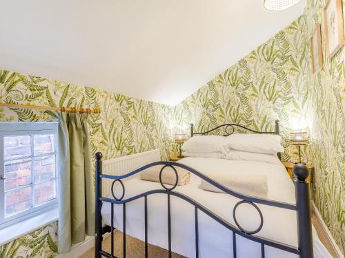 1 dormitorio con 1 cama con papel pintado verde y blanco en Abbots Retreat -uk40757 en Barrow upon Humber