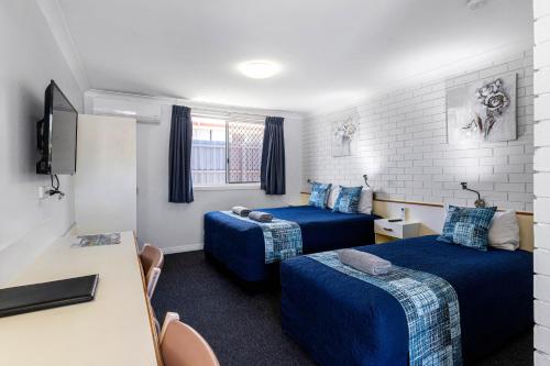 Habitación de hotel con 2 camas y escritorio en Leichhardt Motor Inn, en Toowoomba