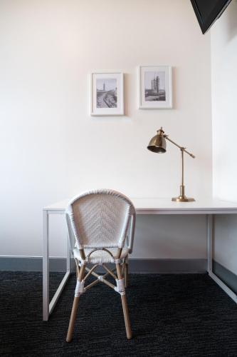a chair sitting in front of a desk with a lamp at Wake Up! Sydney Central in Sydney