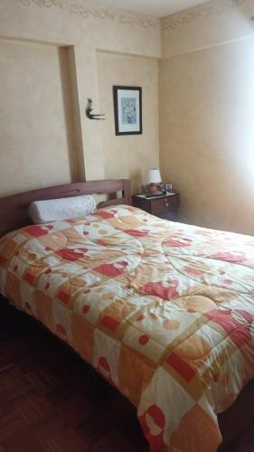een slaapkamer met een bed met een kleurrijke deken bij Hermoso y cómodo departamento en la zona sur cerca a San Miguel in La Paz