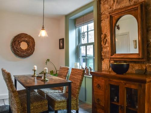 - une salle à manger avec une table, des chaises et un miroir dans l'établissement Kilaine Cottage, à Loftus