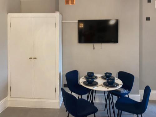 a dining room with a table and blue chairs at Frankfurt Flat - Uk44457 in Two Dales