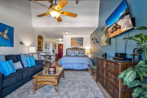 Kihei Bay Surf 208- Updated partial oceanview studio across from beach في كيهي: غرفة معيشة مع سرير وأريكة