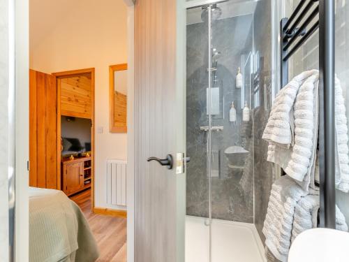 uma casa de banho com um chuveiro e uma porta de vidro em The Lodge em Kirk Ireton