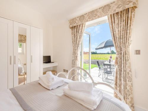 a bedroom with a bed and a view of a patio at The Old Dairy in Hampreston