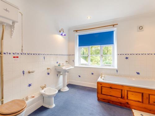 een badkamer met een bad, een toilet en een wastafel bij Manor Farm House - Uk45276 in Sculthorpe