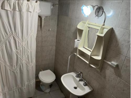 uma casa de banho com um WC, um lavatório e um espelho. em Amplia y Cómoda casa familiar, muy buena ubicación em Villaguay