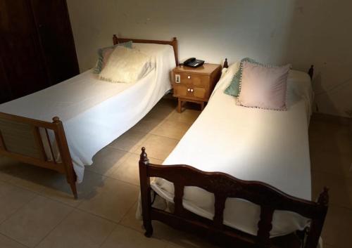 duas camas individuais num quarto com mesa de cabeceira em Amplia y Cómoda casa familiar, muy buena ubicación em Villaguay