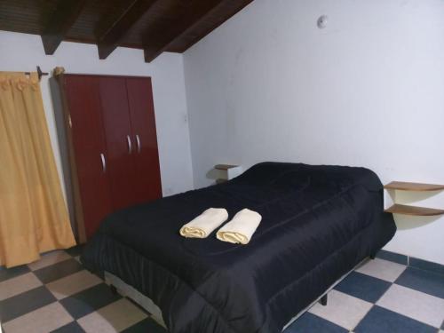 1 dormitorio con 1 cama con 2 zapatillas en Habitacion con baño privado en hermosa casa centrica de Ciudad en Mendoza
