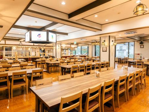 an empty restaurant with wooden tables and chairs at Hotel Ichinose in Yamanouchi