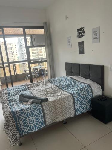 1 dormitorio con cama y ventana grande en Apartamento em frente à praia Barra da Tijuca, en Río de Janeiro