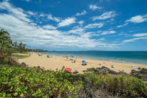 a beach with a lot of people and the ocean at Kihei Alii Kai D207- Ocean view, walk to shops, dining, and Kam I Beach in Kihei