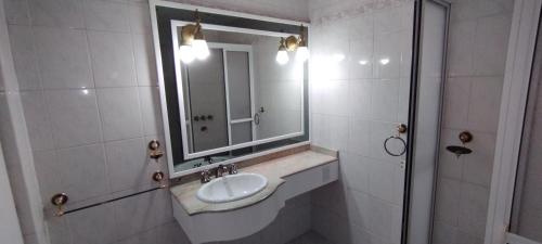 een witte badkamer met een wastafel en een spiegel bij deptoparanacentro in Paraná