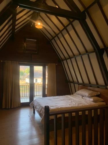 una camera con un letto in una stanza con una finestra di Cemara Siu Bungalow a Sembalun Lawang