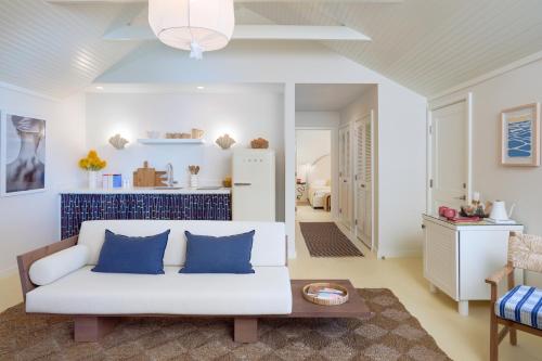 uma sala de estar com um sofá branco e almofadas azuis em Silver Sands Motel & Beach Bungalows em Greenport
