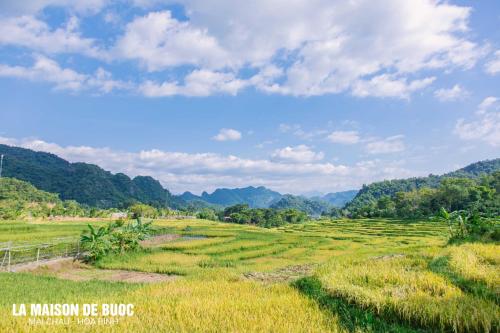 a field in thekkady with mountains in the background at La Maison De Buoc in Mai Chau