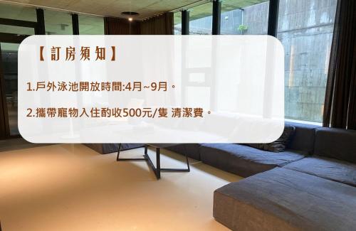 a large white sign in a room with a couch at 宜蘭可以包棟別墅 l 寵物友善 l 烤肉 in Dongshan