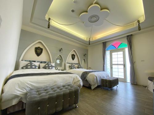 馬公市的住宿－夢的堡壘海景民宿，一间卧室设有两张床和彩虹窗