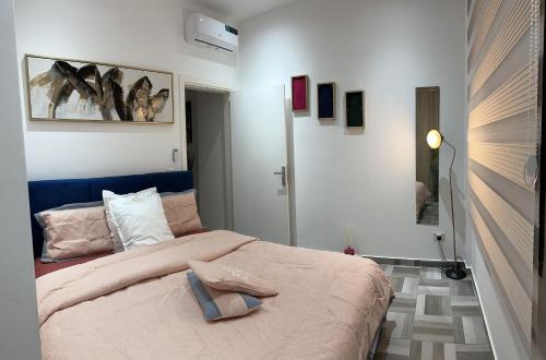 1 dormitorio con 1 cama con cabecero azul en SYN - Corniche en Brazzaville